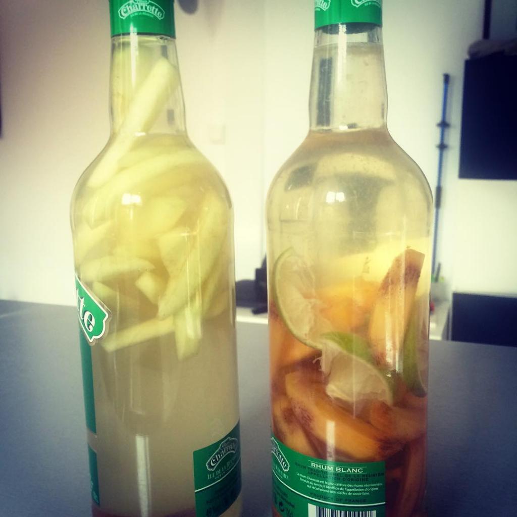 Deux bouteilles de rhum arrangé, kaki et citron vert et gingembre